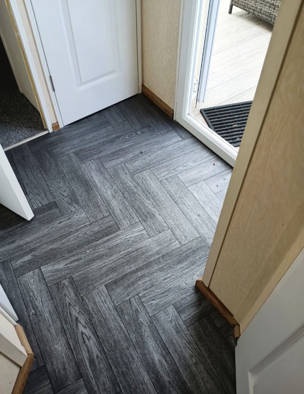 Grey herringbone-effect vinyl professionally fitted in a hallway