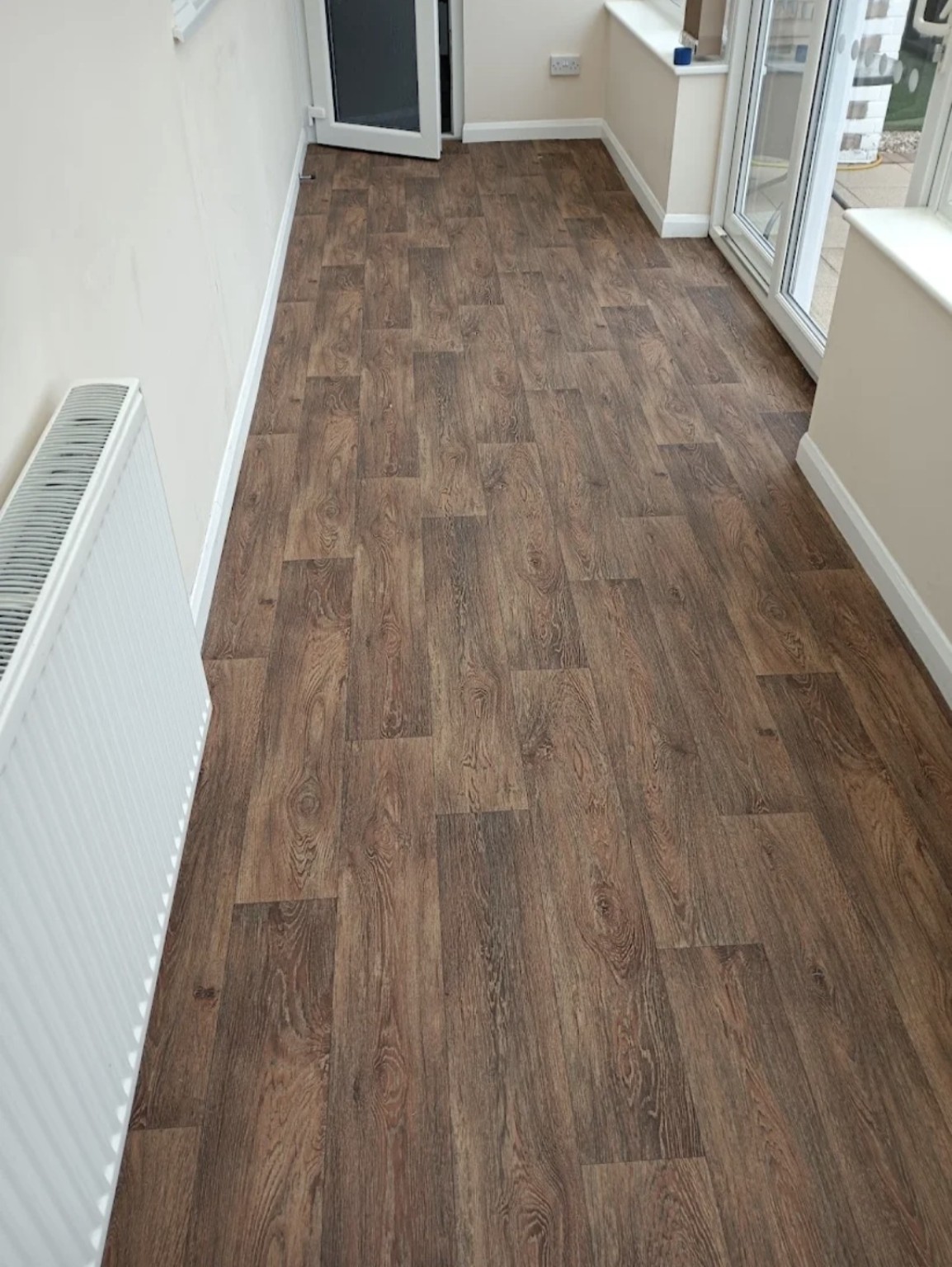 Warm wood-effect vinyl professionally fitted in a conservatory